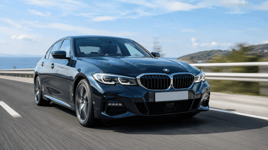 洗練された都会の街並みを背景に並び立つ、白のレクサスISと青のBMW 3シリーズセダンのフロントマスク写真